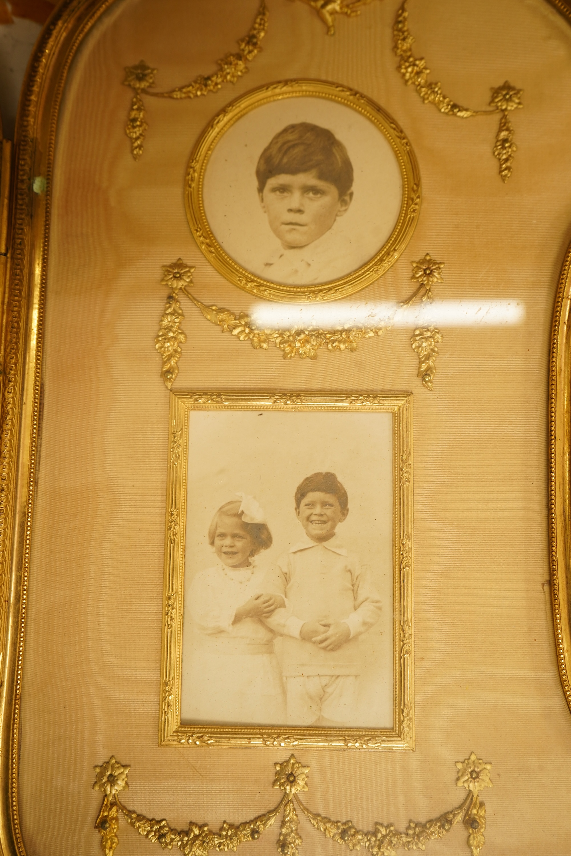 An Edwardian gilt framed triptych photo frame with watered silk backing, overall 72cm wide